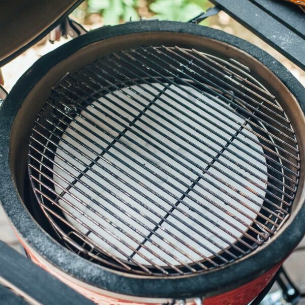 Placa deflectora de cerámica instalada en una parrilla Kamado Joe, lista para la cocción indirecta.