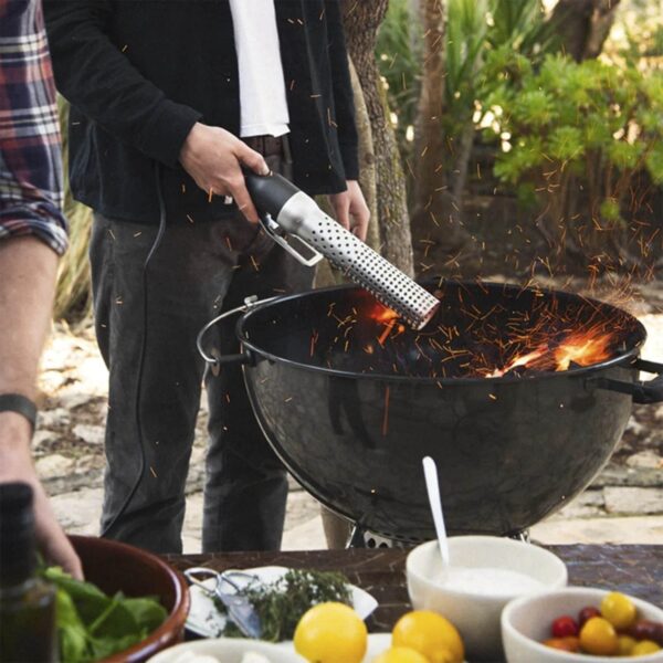 Encendiendo una parrilla kettle con el Looft Lighter I, capturando el momento en que las chispas vuelan.