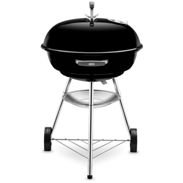 Parrilla de carbón Weber Compact Kettle de 57 cm con diseño elegante en color negro, destacando su tapa y dos ruedas para fácil movilidad.