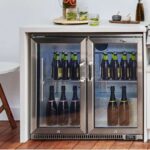 Nevera Beefeater de dos puertas empotrada en una cocina exterior, con botellas de vino y cerveza organizadas en su interior.