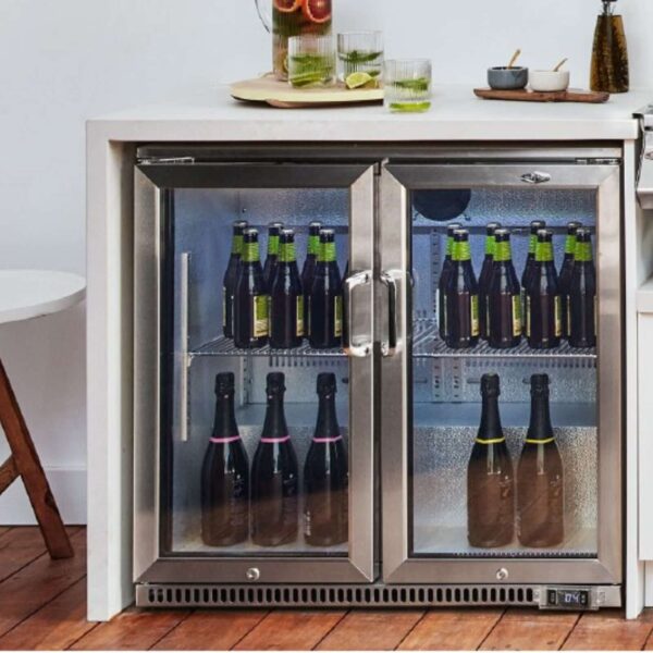 Nevera Beefeater de dos puertas empotrada en una cocina exterior, con botellas de vino y cerveza organizadas en su interior.