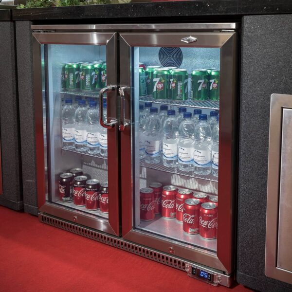 Nevera Beefeater de dos puertas empotrada en cocina de exterior, con puerta de cristal, iluminación LED y bebidas frías organizadas en su interior.