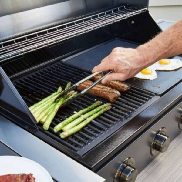 Parrilla BeefEater en uso con carne y vegetales en una barbacoa Discovery.