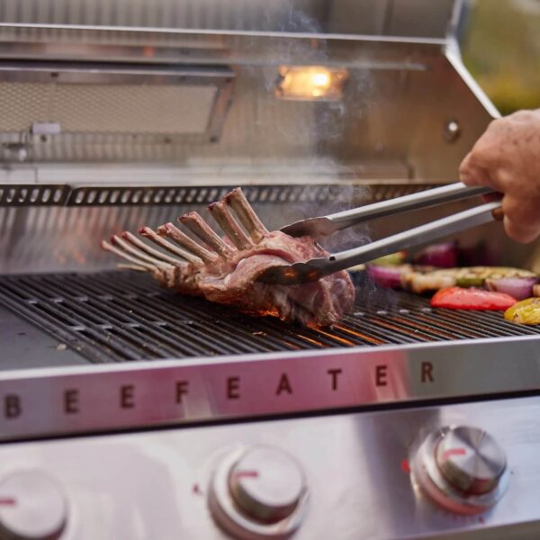 Costillar de cordero cocinándose en la parrilla de la Beefeater Signature 7000 con quemador trasero encendido.