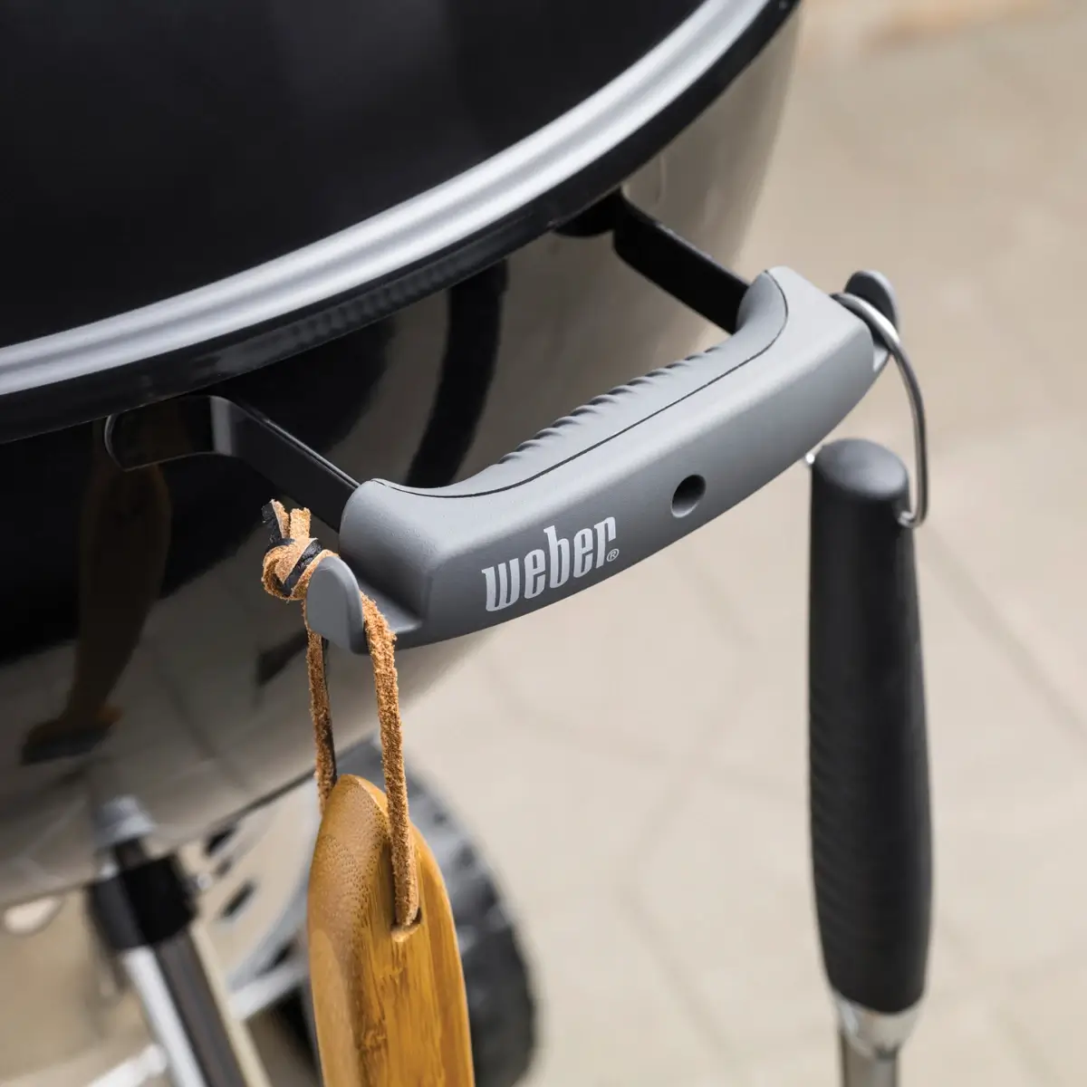 Detalle del mango y gancho portautensilios de la Weber Original Kettle Premium