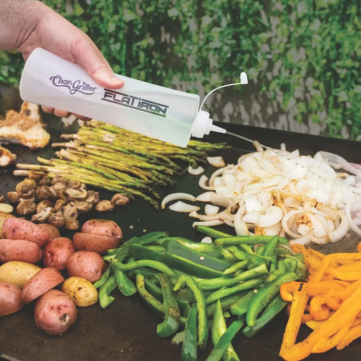 Botella Char-Griller dosificando líquido sobre verduras en una plancha