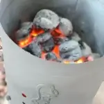 Primer plano del carbón encendido dentro del encendedor de chimenea Char-Griller