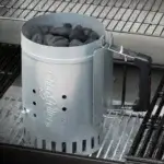 Encendedor de chimenea Char-Griller lleno de carbón colocado sobre la rejilla de una parrilla