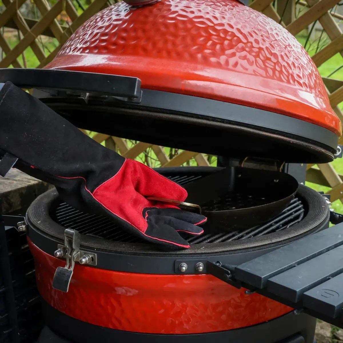 Guante de cuero Kamado Joe junto a la parrilla de un kamado