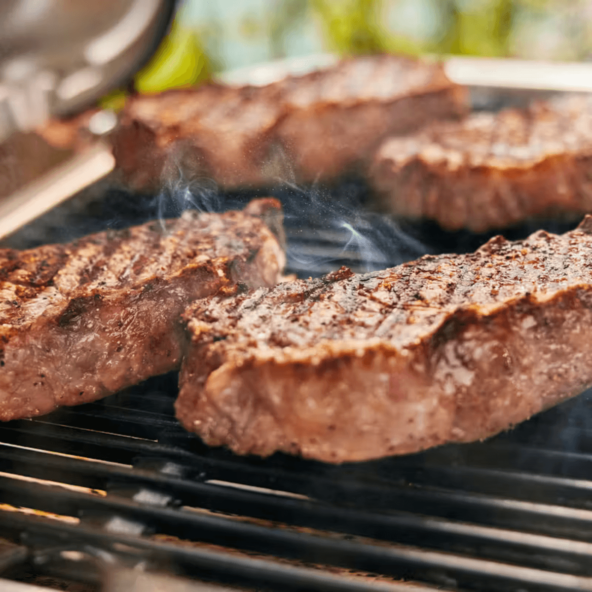 Detalle de uso de la Weber Lumin con soporte y plancha en exterior