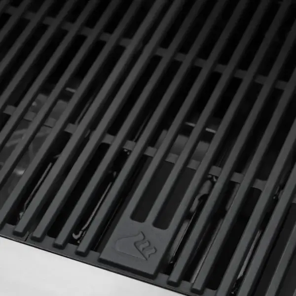 Detalle de las parrillas de hierro fundido de la GrandPro Maxim G5 con emblema de llama.