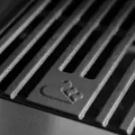 Primer plano de una parrilla de hierro fundido GrandPro con el logotipo de llama en relieve.