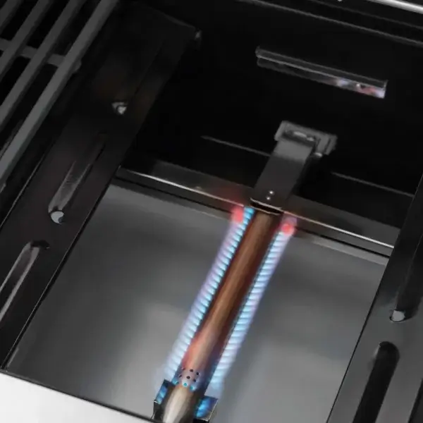 Quemador tubular de la GrandPro Maxim G5 encendido con llama azul bajo la zona de cocción.
