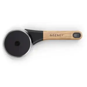 Gozney Pizza Cutter visto desde arriba, con rueda circular negra, filo metálico y mango de madera.
