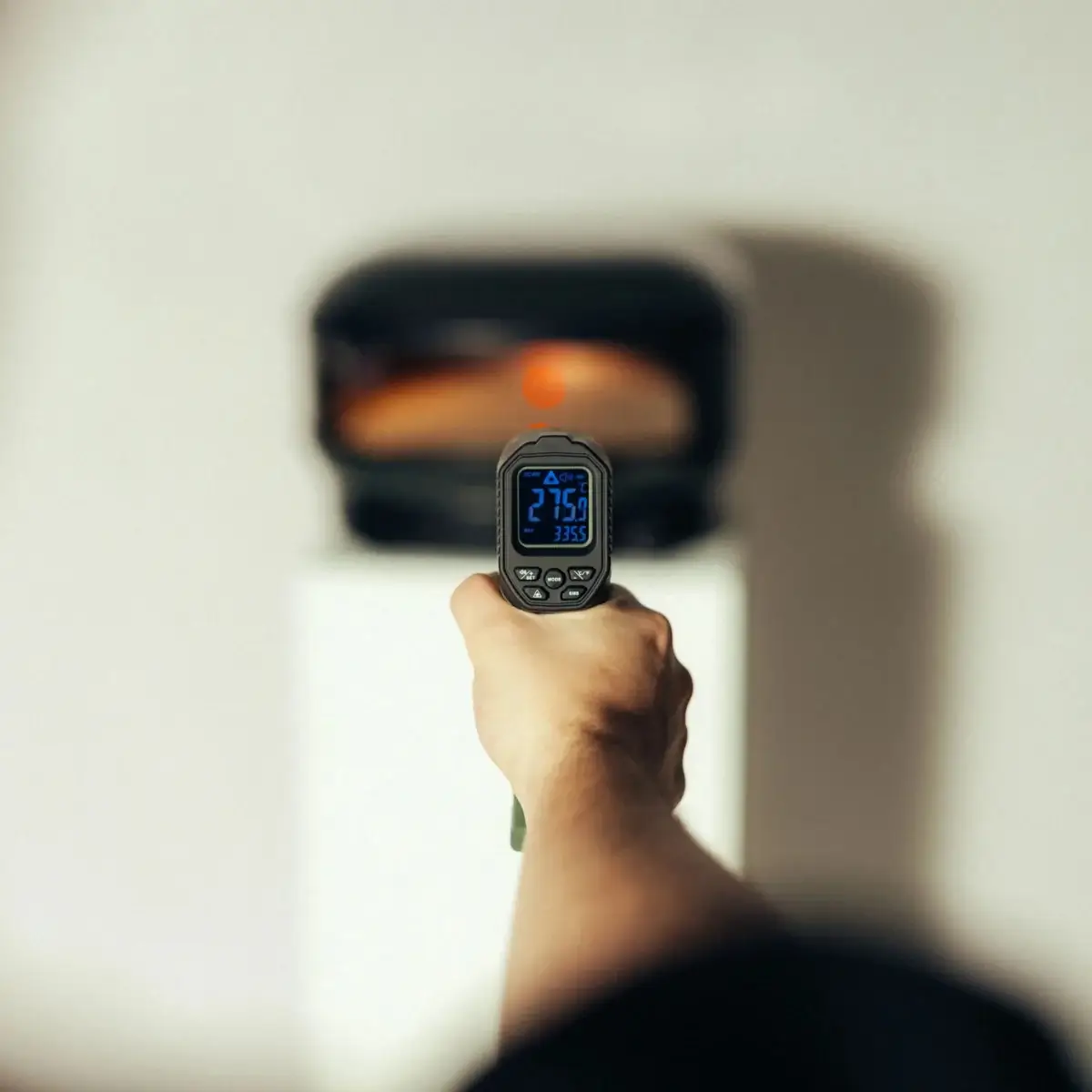 Control de temperatura en horno de pizza con termómetro infrarrojo Gozney Termómetro infrarrojo Gozney midiendo la superficie de un horno de pizza encendido