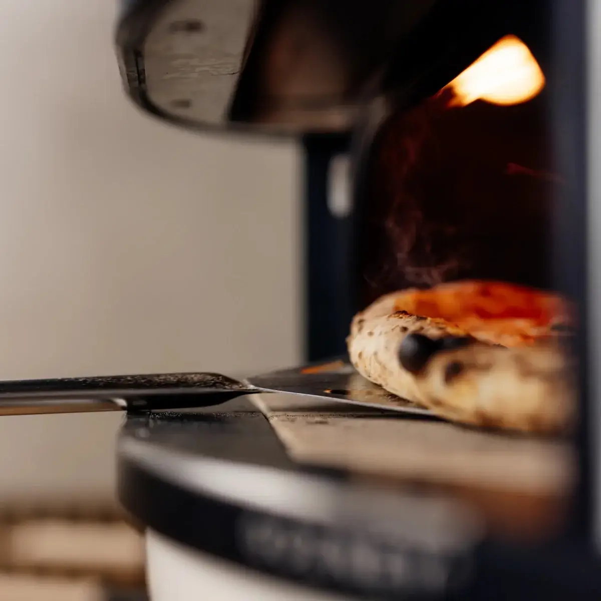 Pala Gozney Balance trabajando con una pizza dentro del horno