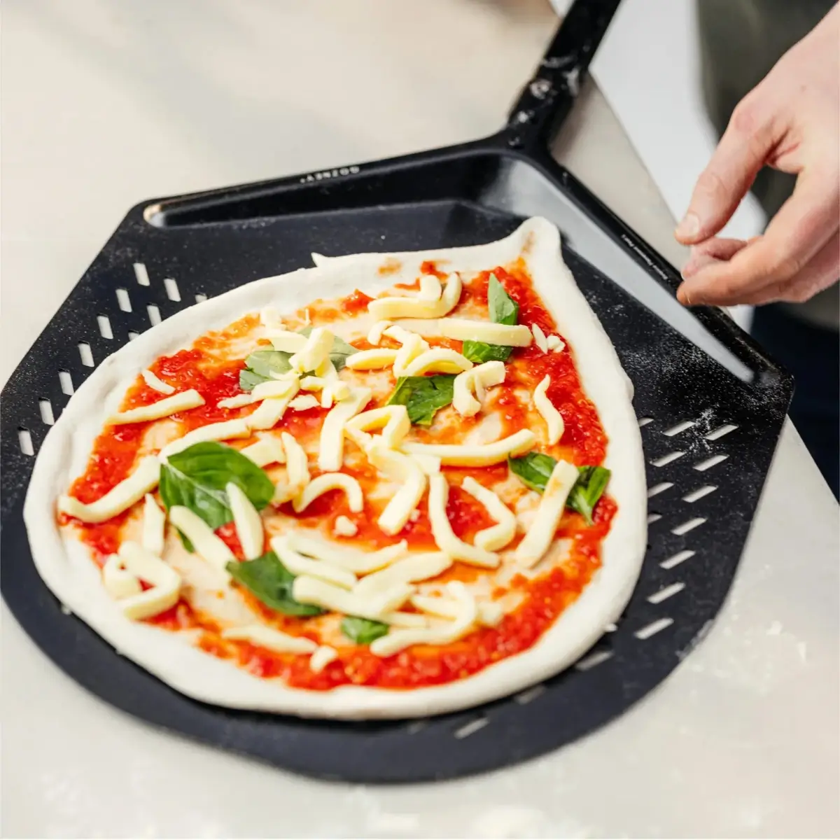Preparación de pizza con la pala Gozney Balance de 12 pulgadas