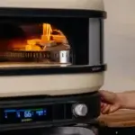 Leña ardiendo sobre la rejilla metálica del Gozney Wood-Fire Control Kit dentro de un horno Dome.