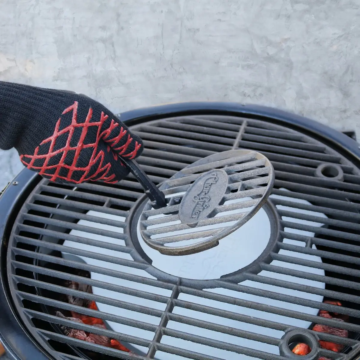 Guante de barbacoa Char-Griller sujetando una rejilla de parrilla