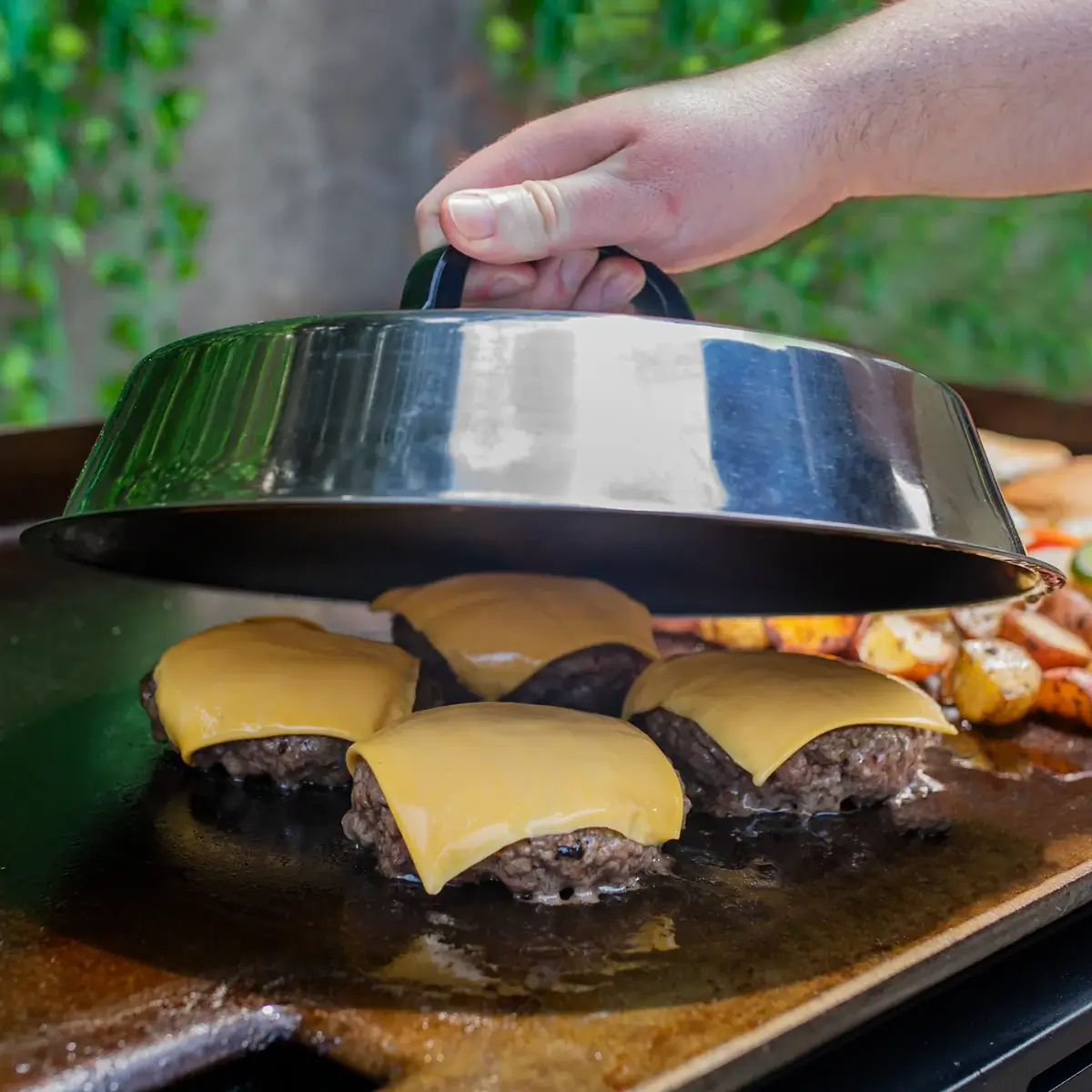 Cúpula Char-Griller sobre hamburguesas con queso en una plancha