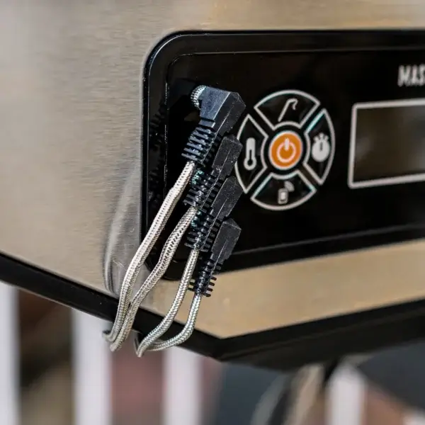 Cuatro cables de sondas de temperatura conectados al panel digital de un Masterbuilt Gravity Series.