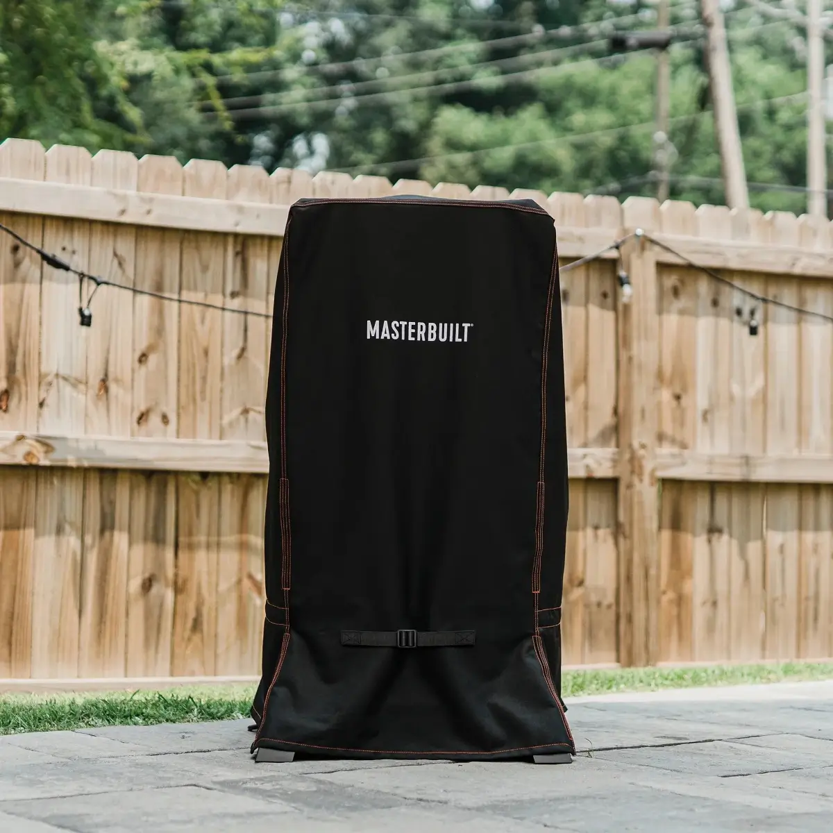Ahumador Masterbuilt protegido con funda en un patio exterior