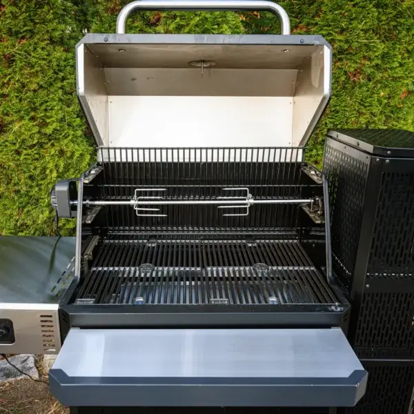 Kit rostizador instalado en una parrilla Masterbuilt Gravity Series abierta en un entorno exterior.