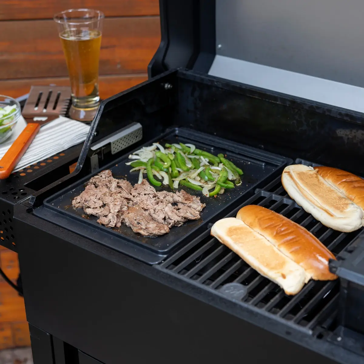 Plancha Masterbuilt y rejilla utilizadas simultáneamente con carne verduras y pan