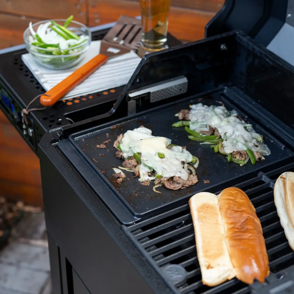 Carne cebolla y queso sobre la plancha Masterbuilt junto a panecillos