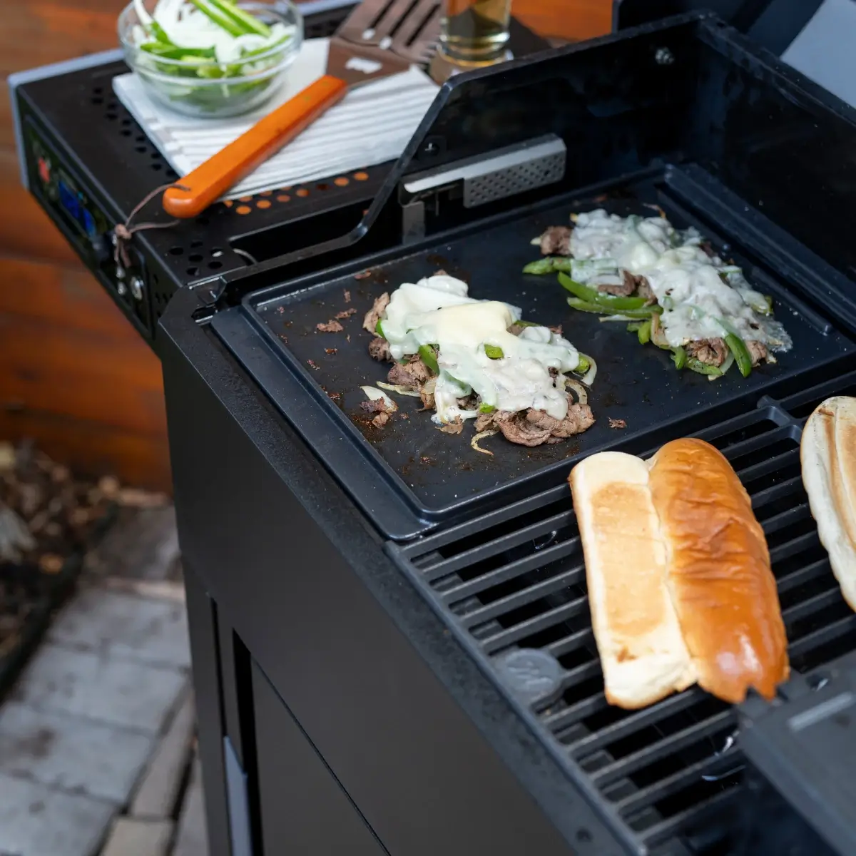 Cheesesteaks con carne cebolla queso y panecillos preparados en la plancha Masterbuilt